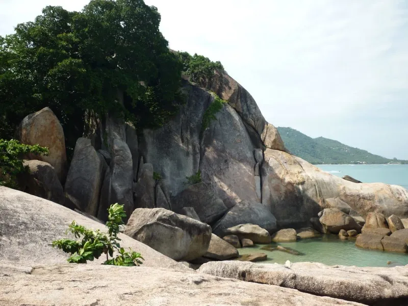 Granite boulders and a tidepool shaded by a tree near Hin Ta Hin Yai on Lamai Beach, Koh Samui
