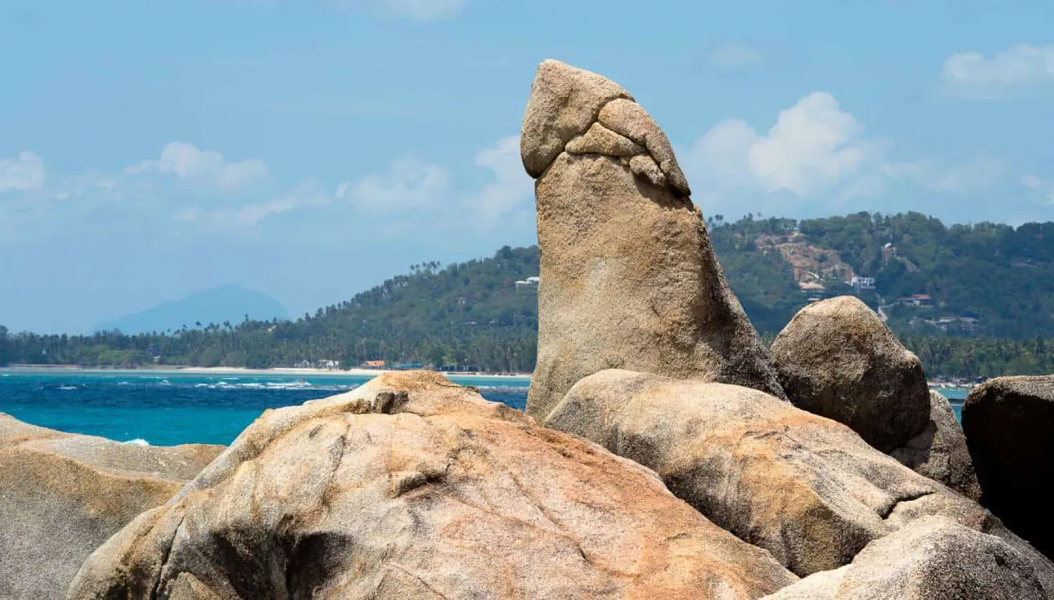 Hin Ta, the upright grandfather rock, with Lamai village and the coastline visible behind it