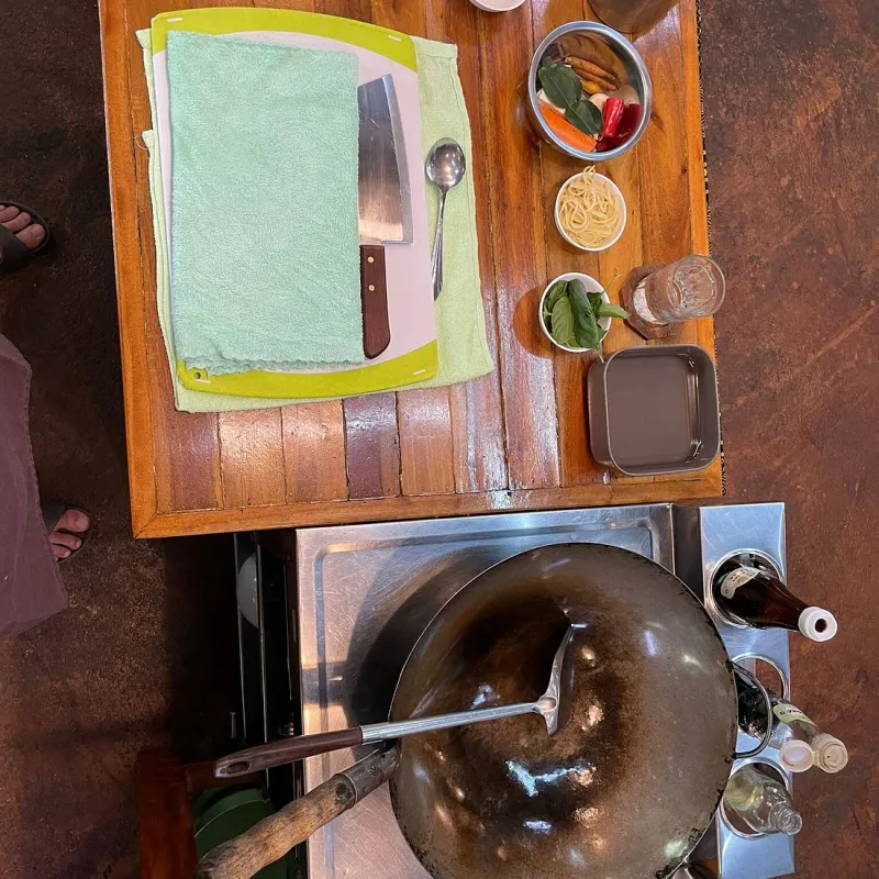An overhead view of a wok station with knife, chopping board and prepped ingredients at Island Organics Samui