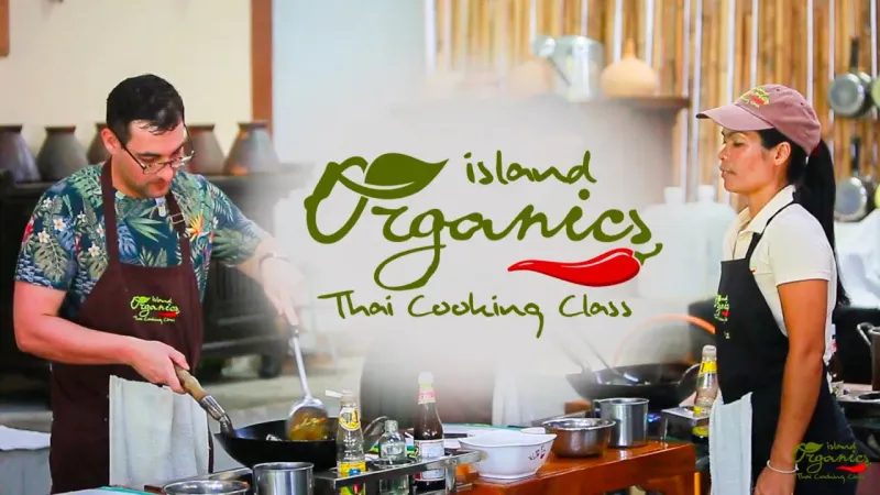Island Organics Samui's own promotional photo of two cooks at the wok station, branded aprons visible