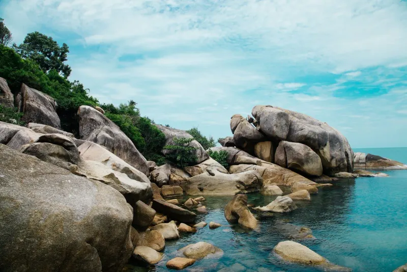 A rocky Koh Samui shoreline, illustrative of the coastline visible from the island's high ground