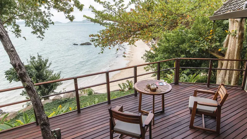Terrazza di legno del Kamalaya Koh Samui sul pendio, con vista sulla baia di sabbia e sul mare