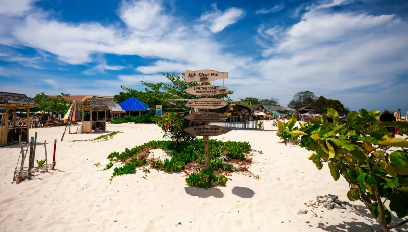 Clear blue skies over a quiet beach near Koh Samui with a wooden signpost