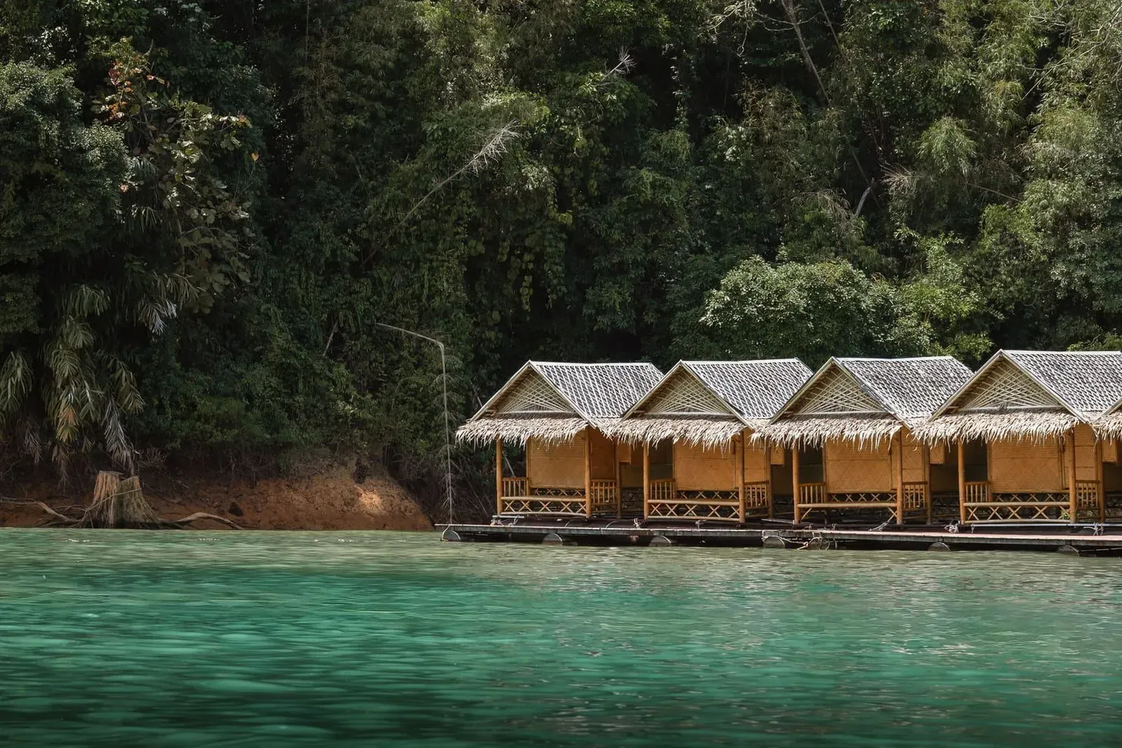 Floating raft house bungalows moored beside jungle-covered hills on Cheow Lan Lake Khao Sok