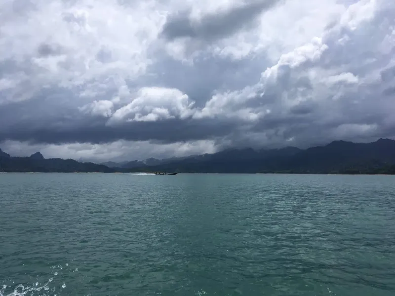 Wide view of Cheow Lan Lake's turquoise water framed by dense rainforest near Khao Sok