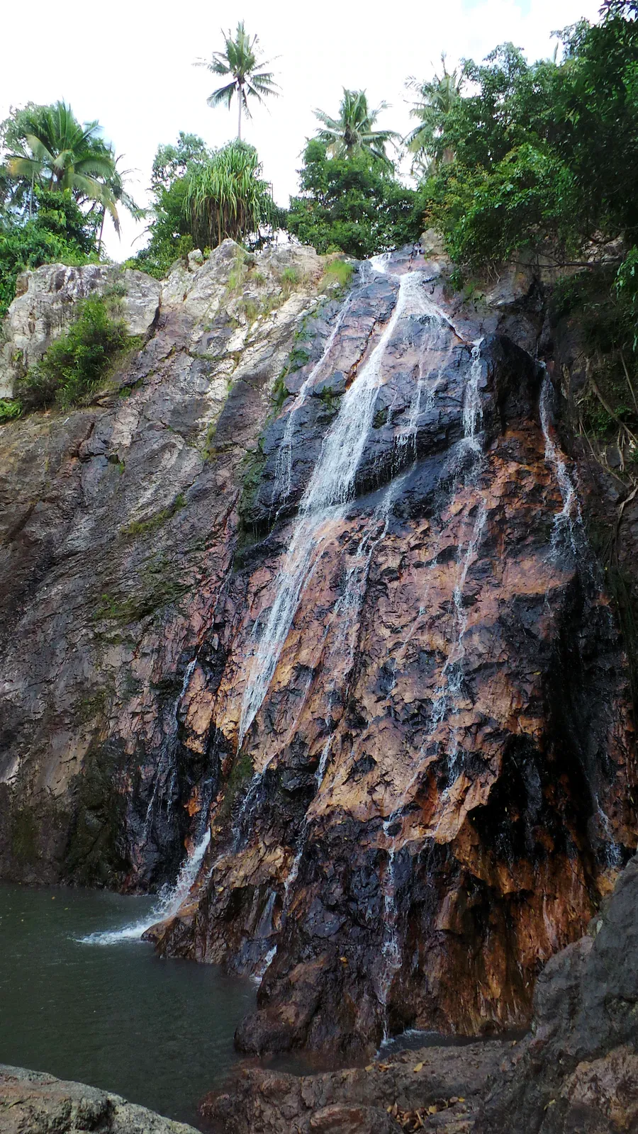 Khun Si Wasserfall mit mehrstufiger Kaskade über dunklen Granitfelsen