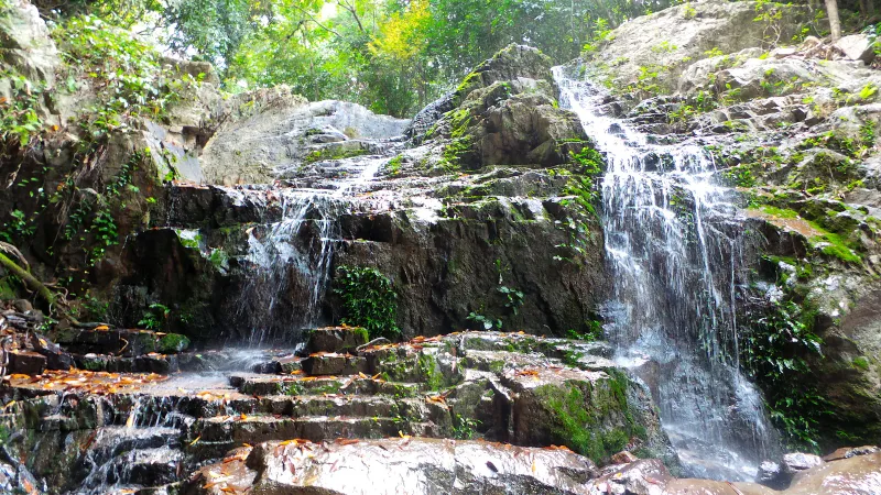 Khun Si Wasserfall stürzt über Granitfelsen im Dschungel
