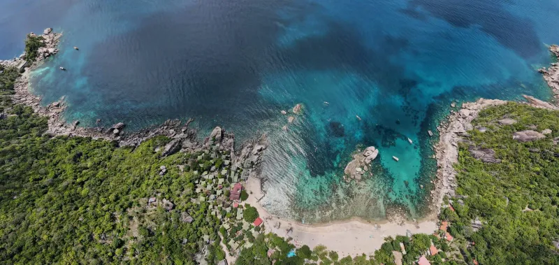 Aerial shot of tropical coastline with lush greenery near Koh Tao on the Koh Samui day trip route