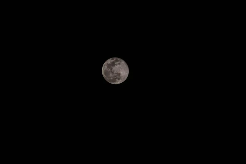 Detailed view of a full moon against a dark night sky above the Gulf of Thailand