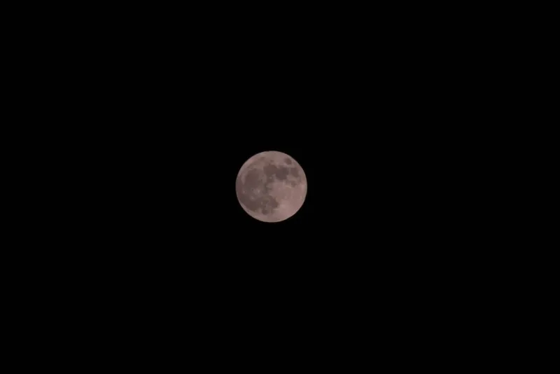 Bright full moon illuminating a dark night sky, the monthly marker for Koh Phangan's beach parties