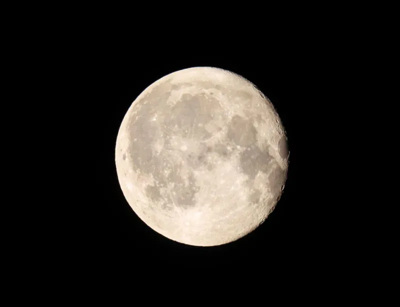 Full moon captured clearly against a dark night sky ahead of a beach party night