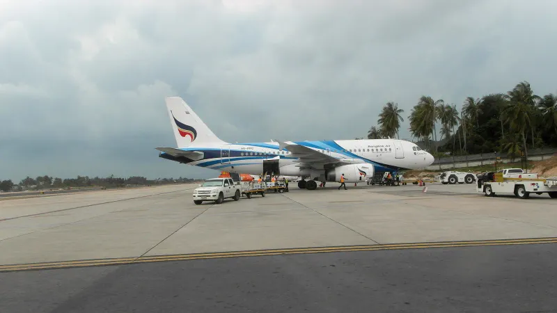 Jet Bangkok Airways sul piazzale dell'aeroporto di Koh Samui con palme sullo sfondo