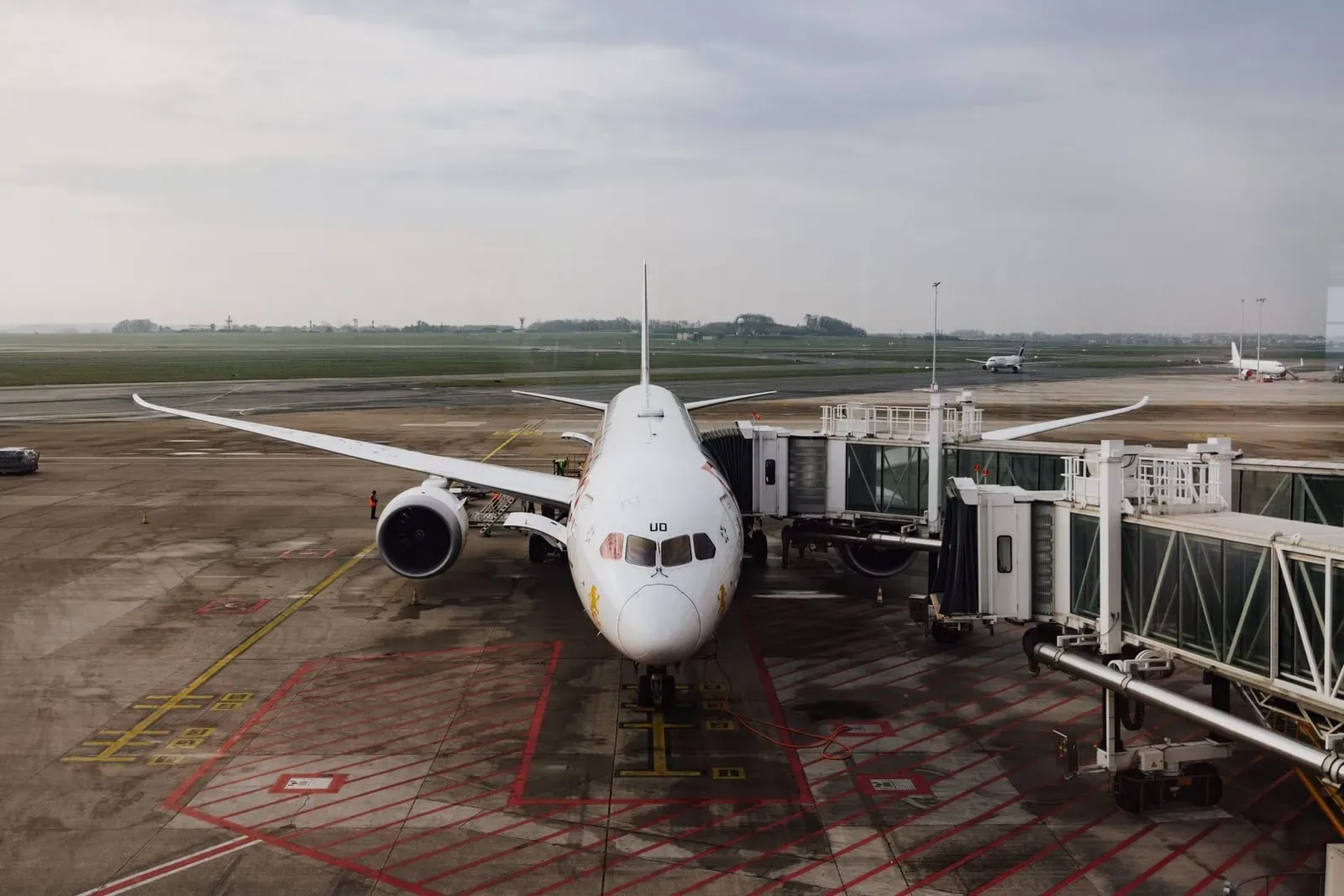 Passenger jet parked at an airport gate under a cloudy sky representing Bangkok Airways service to Koh Samui