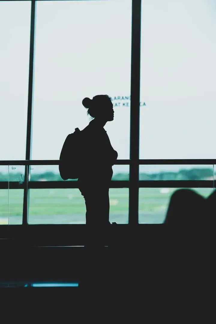 Traveler with backpack standing in an airport terminal waiting for a Koh Samui departure