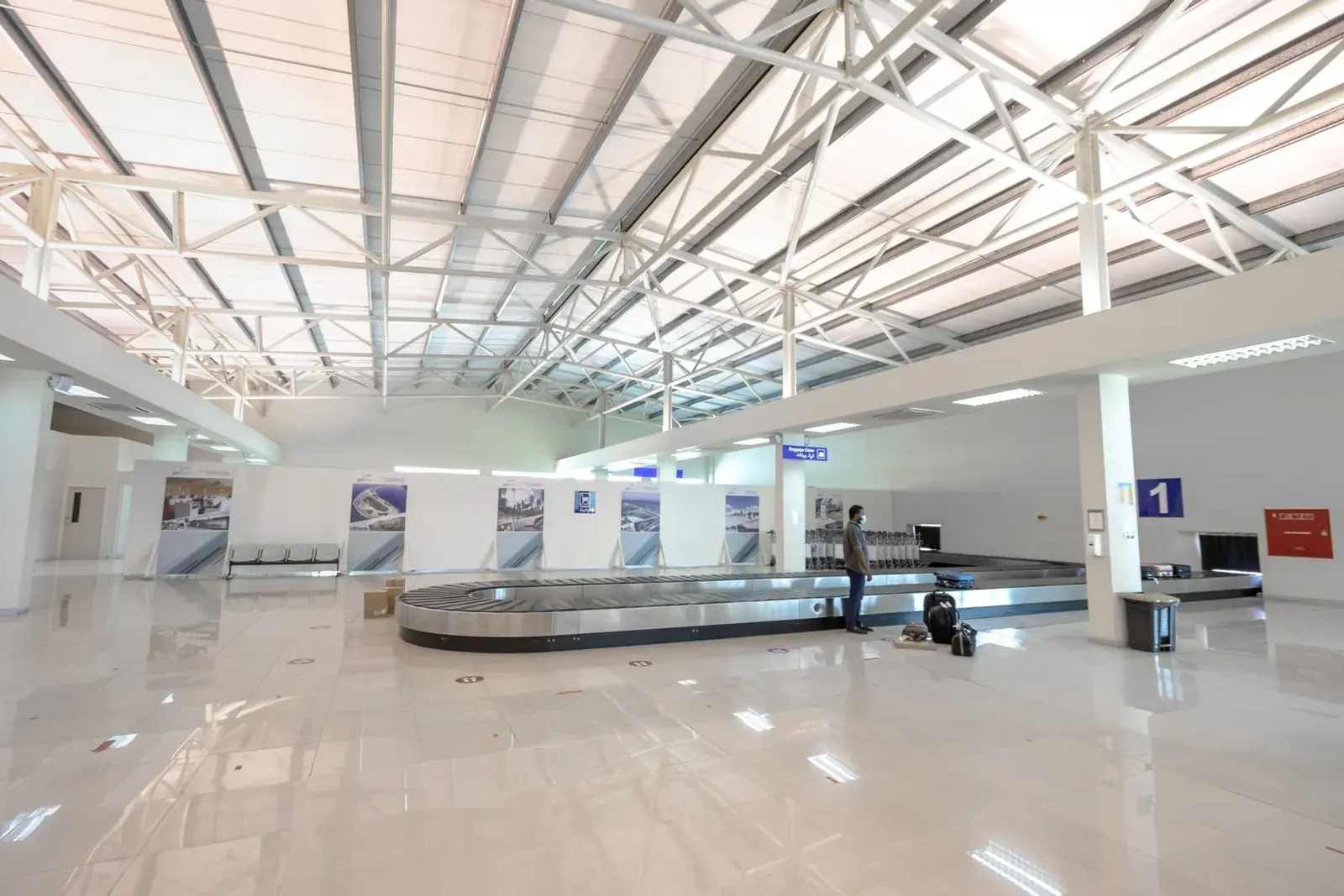 Traveler waiting in a quiet airport baggage claim area similar to Koh Samui Airport arrivals hall