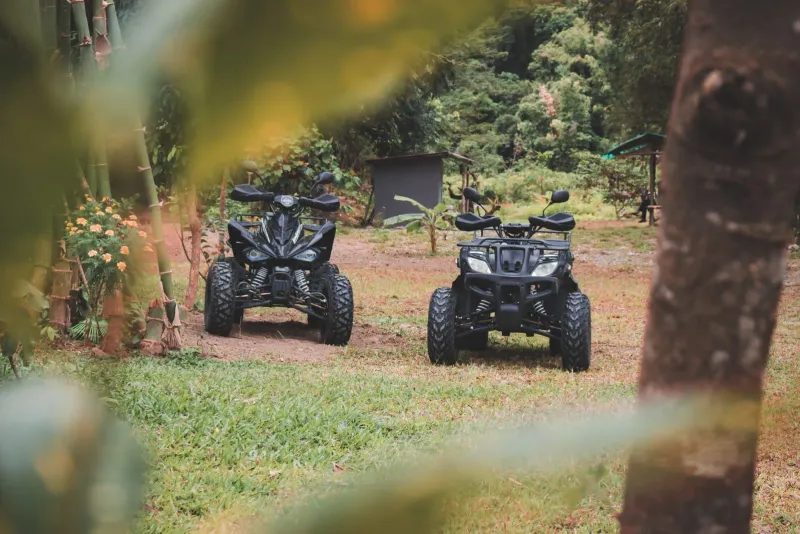 Two all-terrain vehicles parked in a jungle clearing before a Koh Samui ATV tour