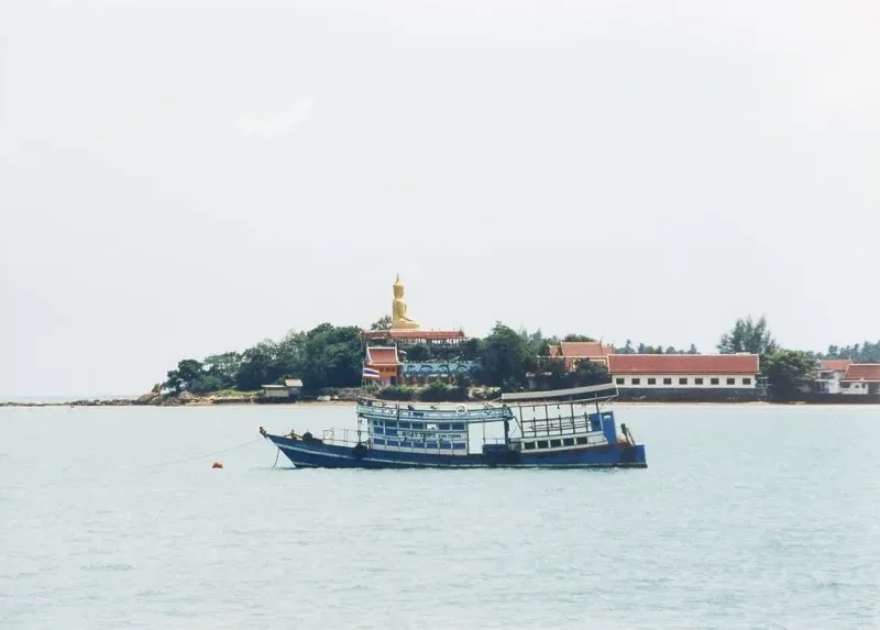 Statua dorata del Big Buddha al tempio di Wat Phra Yai a Koh Samui, vista dalla strada rialzata