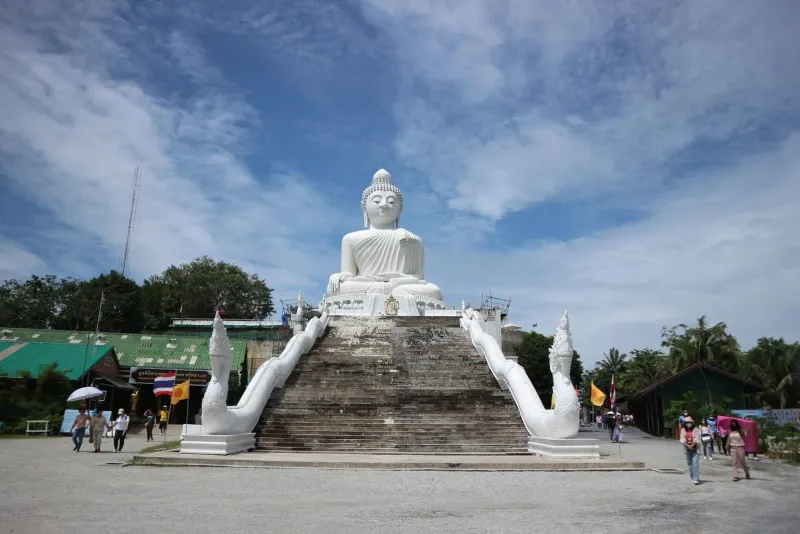 Large seated golden Buddha statue on a hilltop, echoing the pose of Koh Samui's Big Buddha