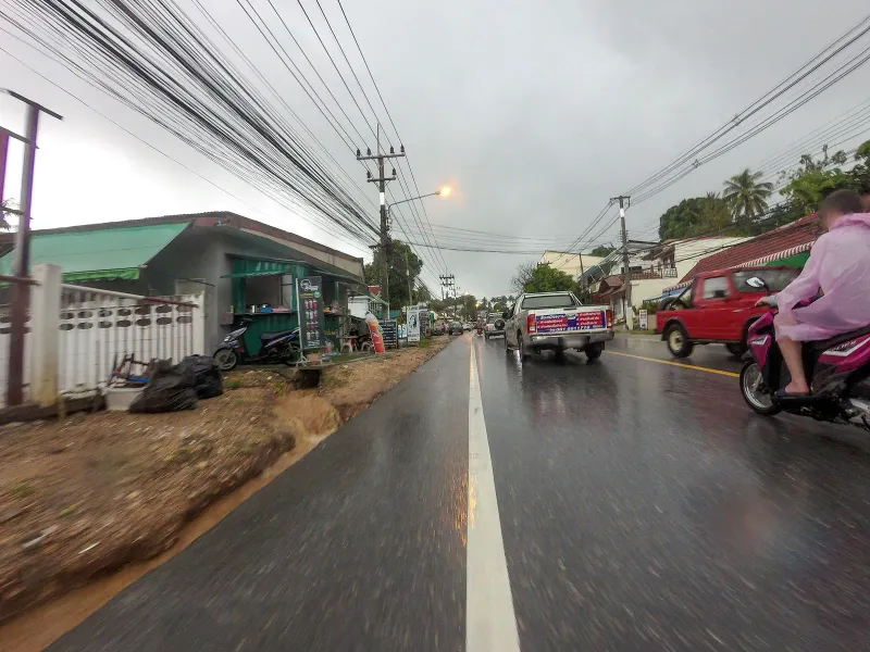 Pickup trucks and a motorbike on Route 4169 near Lamai village in the rain, Koh Samui