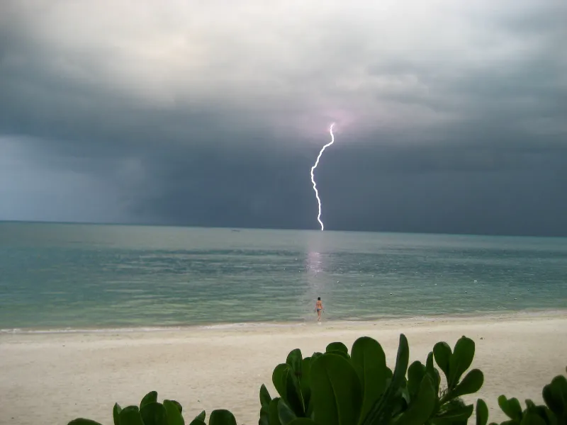Lightning striking the sea off Koh Samui during a monsoon storm, seen from a beach near Lamai