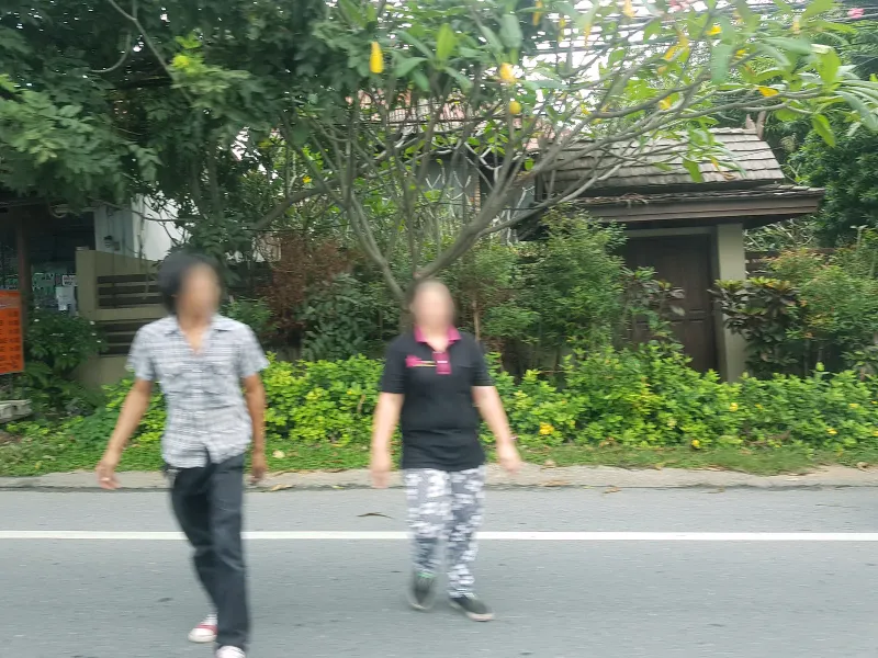 Pedestrians walking along the ring road near a temple gate in the Lamai area, Koh Samui