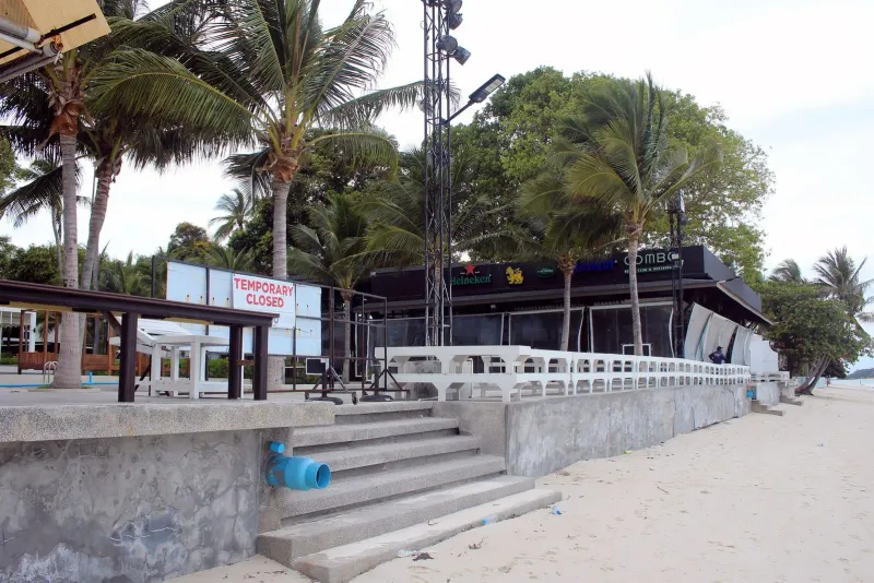 Beachfront beach club building on Chaweng Beach with palm trees and empty loungers before opening