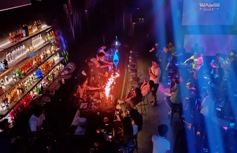 Wide shot of a bartender fire show performance at a Chaweng Beach club on Koh Samui