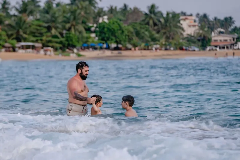 Father and children enjoying calm tropical water on a Koh Samui family beach
