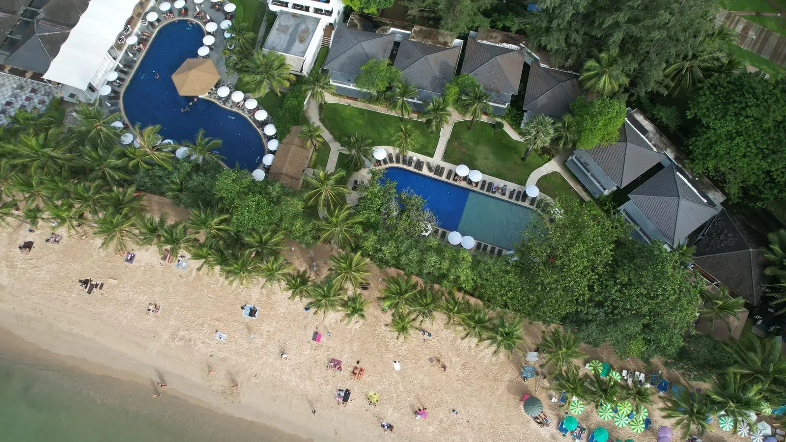Aerial view of a beachfront resort pool beside white sand on Koh Samui's east coast