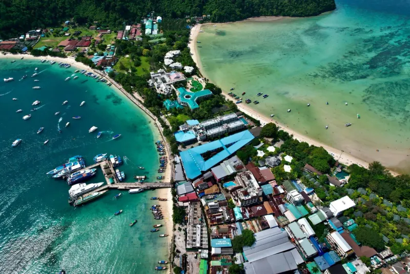 Aerial drone view of a tropical village and beach similar to Koh Samui's Fisherman's Village area