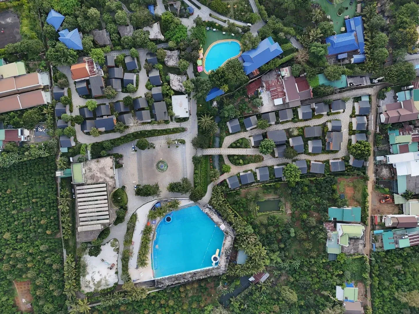 Aerial view of a Koh Samui luxury resort with private pools and villas set among coastal greenery
