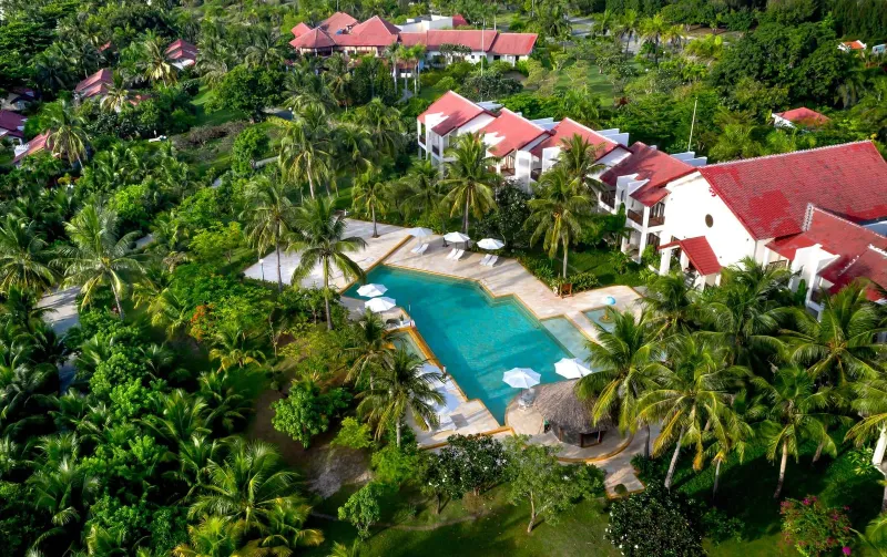 Aerial shot of a Koh Samui luxury resort pool and villas among palm trees