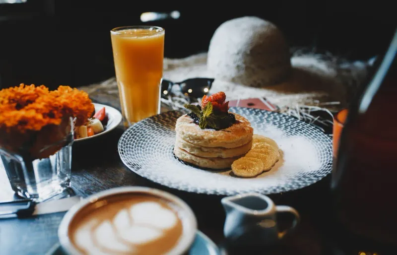 Breakfast dessert and juice with coffee on a wooden table at a Koh Samui brunch spot