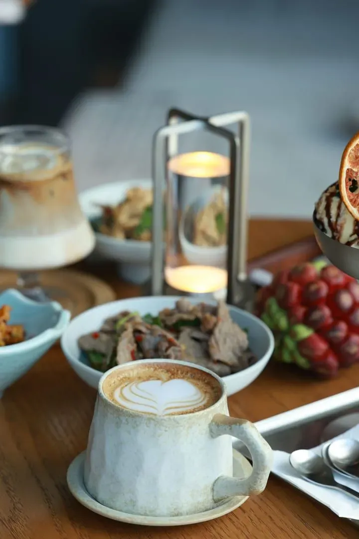 Elegant breakfast spread with coffee, fruit and pastries on a wooden table, typical of Koh Samui health-focused cafes