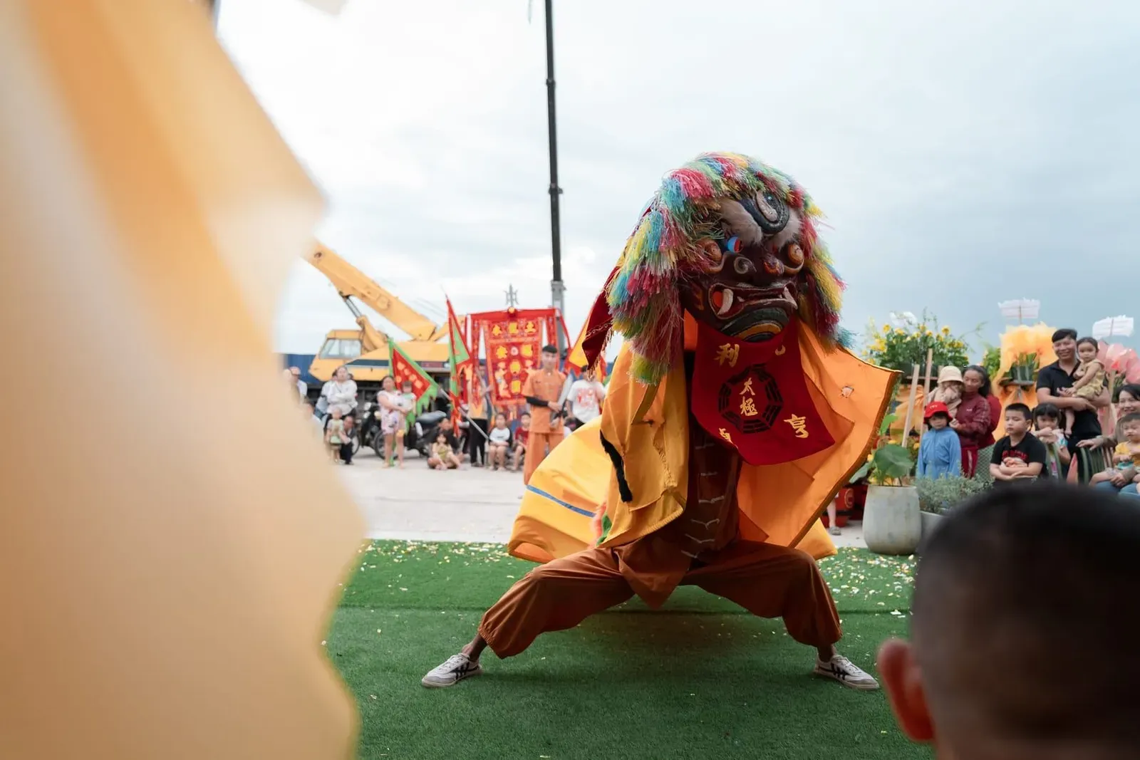 Outdoor lion dance performance with an engaged crowd watching the festival celebration