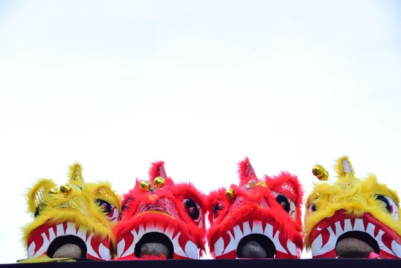 Colorful Chinese lion dance costumes displayed against a clear sky
