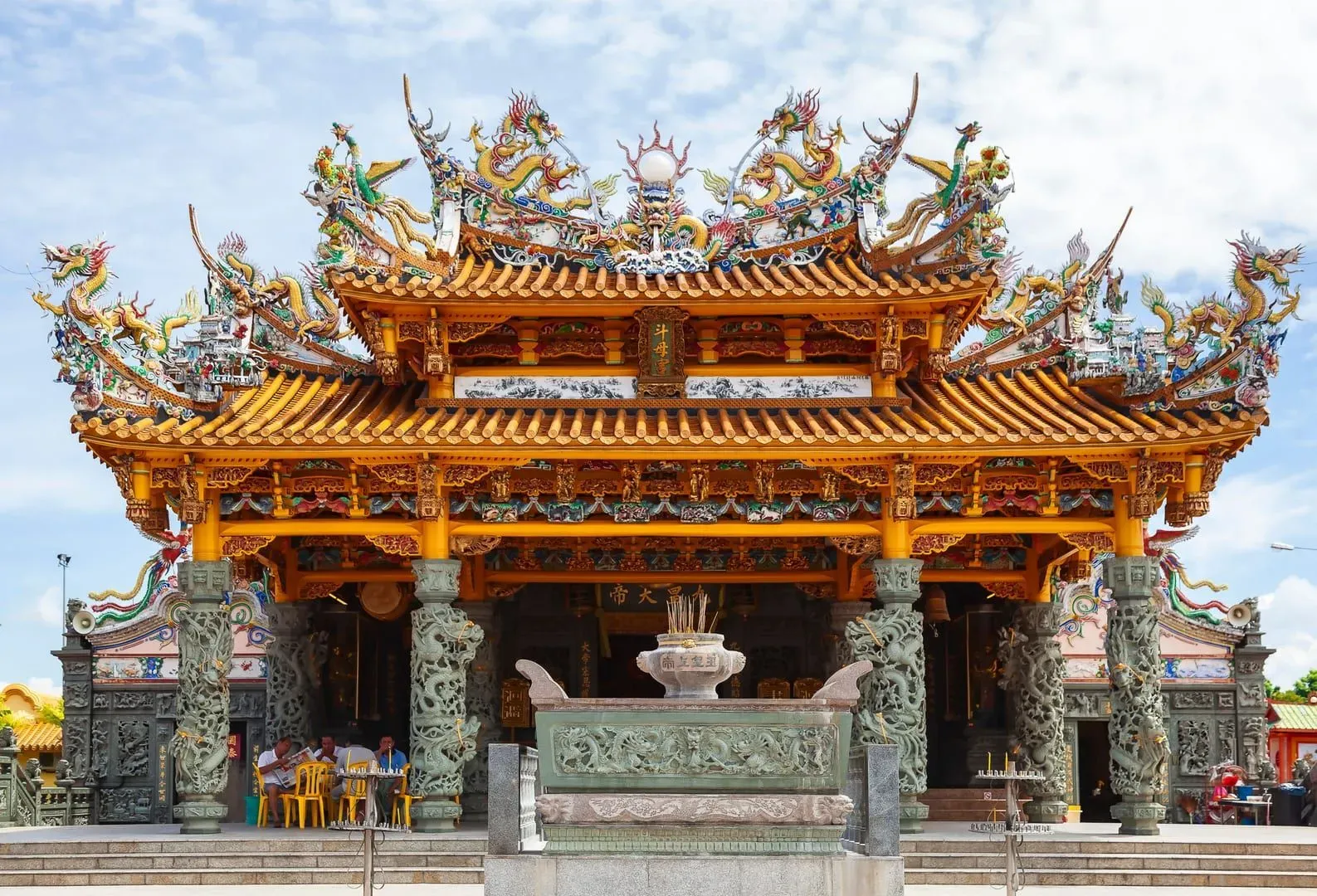 Ornate Chinese temple roofline with dragon sculptures, the style seen on Koh Samui's Hainanese shrines