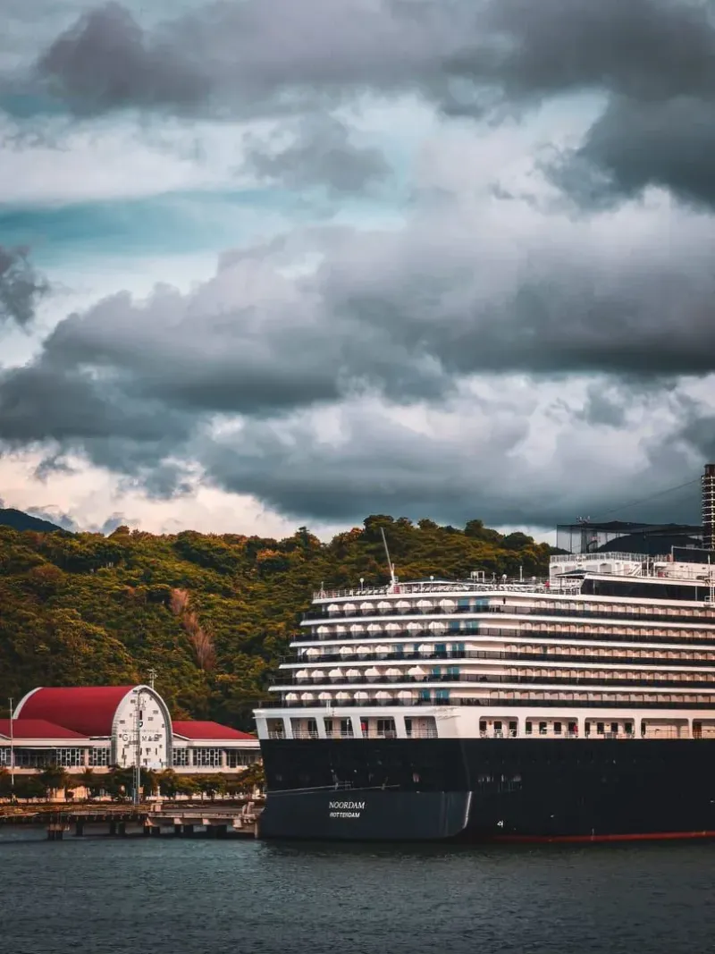 Cruise ship at a scenic port under dramatic clouds, evoking monsoon-season conditions on Koh Samui