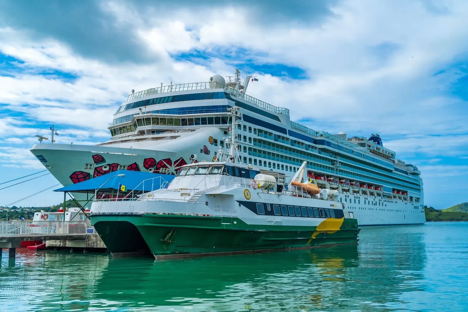 Cruise ship and smaller ferry docked in turquoise water, similar to the mix of vessels seen off Koh Samui's coast