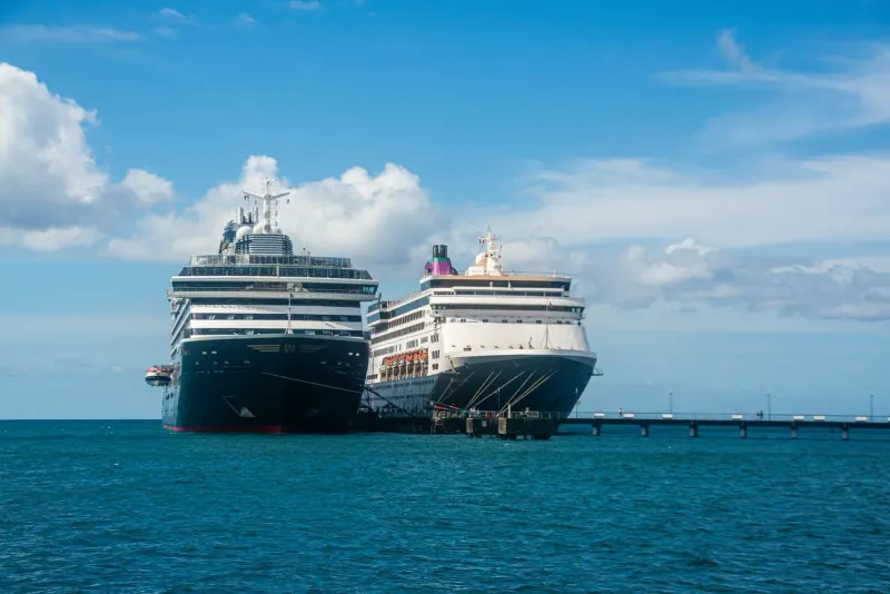 Two cruise ships at a sunny harbor with calm blue water, the kind of calm sea that speeds up tenders