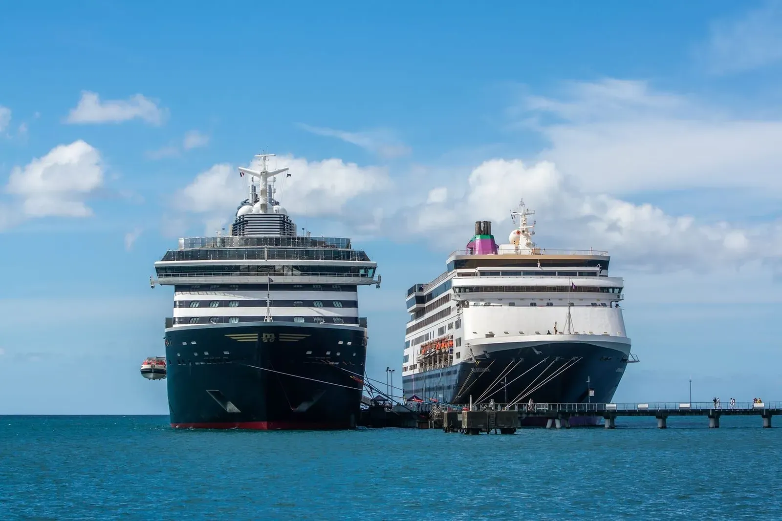 Two large cruise ships docked under clear blue sky, illustrating the kind of vessel that anchors off Koh Samui