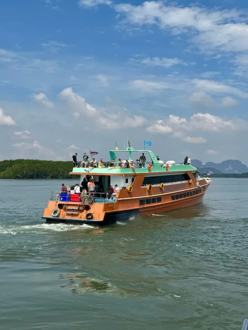Ferry crossing a scenic tropical lake similar to Cheow Lan Lake on the Khao Sok day trip