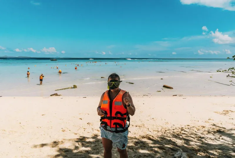 Snorkeler on a sunny Koh Samui beach preparing for reef-safe swimming