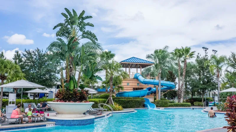 Vibrant tropical resort pool with waterslide and palm trees at a Koh Samui family hotel