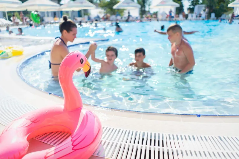 Children playing with pool floats at a Koh Samui family resort on a bright day
