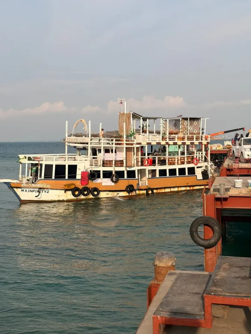 Passenger ferry docked at a Thai pier under a clear sky before departure