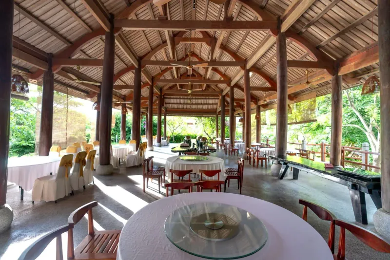 Open-air restaurant patio with wooden archway and table settings on Koh Samui