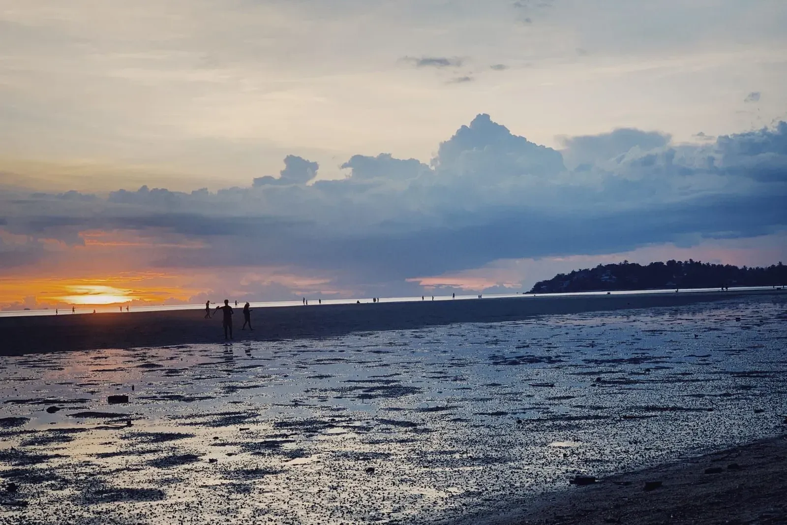Visitors walking along a Koh Samui beach at sunset, a free evening activity