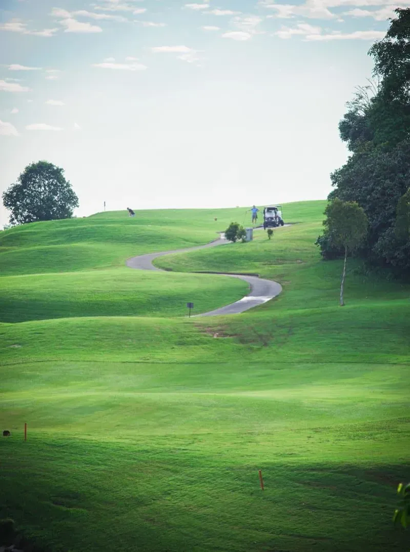Winding path through a lush green golf course on a sunny day near koh samui