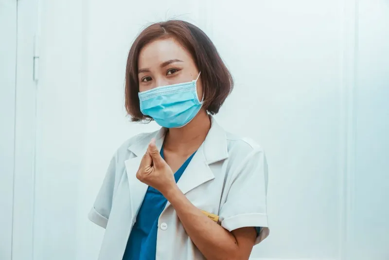 Female doctor in a face mask attending to patient care at a Koh Samui hospital